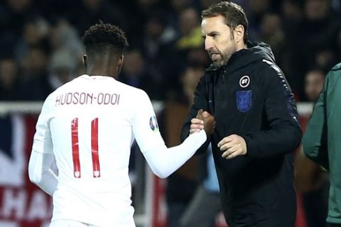 England's Callum Hudson-Odoi, left, shakes hands with England's coach Gareth Southgate after his substitution during the Euro 2020 group A qualifying soccer match between Kosovo and England at Fadil Vokrri stadium in Pristina, Kosovo, Sunday, Nov. 17, 2019. (AP Photo/Boris Grdanoski)