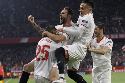 Sevilla's Mercado, left, celebrates with teammates Layun and Roque Mesa, right, after scoring against Real Madrid during La Liga soccer match between Sevilla and Real Madrid at the Sanchez Pizjuan stadium, in Seville, Spain on Wednesday, May 9, 2018. (AP Photo/Miguel Morenatti)