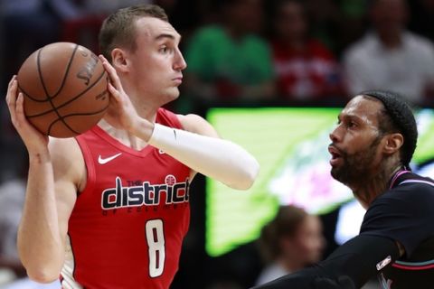 Washington Wizards forward Sam Dekker (8) looks for an opening past Miami Heat forward James Johnson (16) during the second half of an NBA basketball game, Friday, Jan. 4, 2019, in Miami. The Heat defeated the Wizards 115-109. (AP Photo/Wilfredo Lee)
