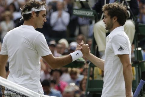 Roger Federer of Switzerland, left,  shakes hands at the net  with Gilles Simon of France after winning their quarterfinal singles match, at the All England Lawn Tennis Championships in Wimbledon, London, Wednesday July 8, 2015.  Federer won 6-3, 7-5, 6-2. (AP Photo/Pavel Golovkin)