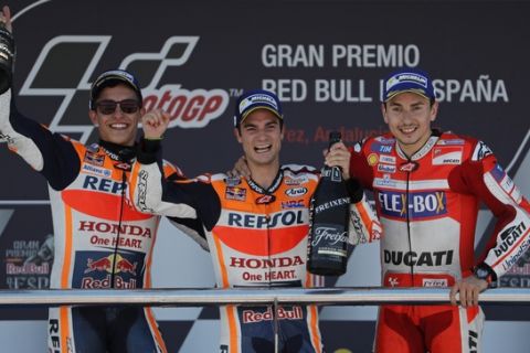 MotoGP riders Dani Pedrosa, center, 2nd placed Marc Marquez left and 3rd placed Jorge Lorenzo, all from Spain, celebrate on on podium at the Spanish Motorcycle Grand Prix at the Jerez racetrack in Jerez de la Frontera, Spain, Sunday, May 7, 2017. (AP Photo/Miguel Morenatti)