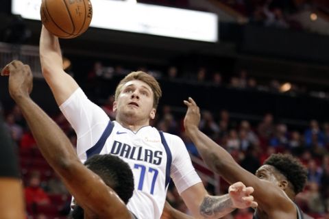 Dallas Mavericks forward Luka Doncic (77) dunks the ball over Houston Rockets guard James Harden, left, and Danuel House Jr., right, during the first half of an NBA basketball game, Wednesday, Nov. 28, 2018, in Houston. (AP Photo/Michael Wyke)