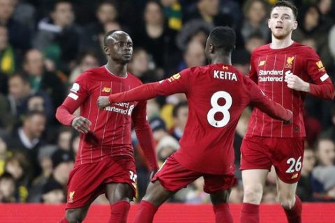 Liverpool's Sadio Mane, left, celebrates with teammates after scoring his side's opening goal during the English Premier League soccer match between Norwich City and Liverpool at Carrow Road Stadium in Norwich, England, Saturday, Feb. 15, 2020. (AP Photo/Frank Augstein)