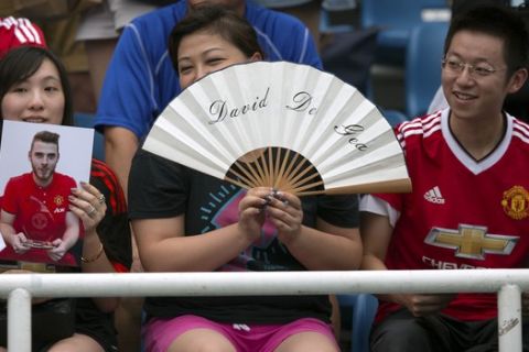Chinese fans of Manchester United's goalkeeper David De Gea watch the team's training session at the Olympic Sports Center Stadium in Beijing, Sunday, July 24, 2016. Manchester United will play a friendly soccer match against Manchester City in Beijing on Monday night. (AP Photo/Mark Schiefelbein)