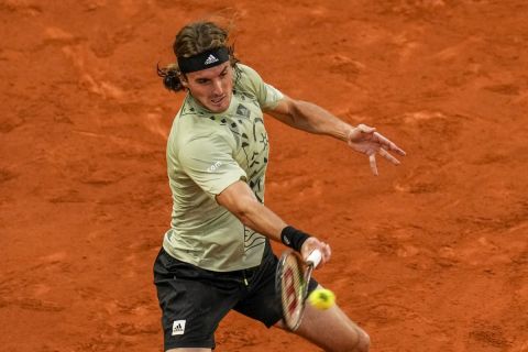 Greece's Stefanos Tsitsipas returns the ball against Andrei Rubliov during their match at the Mutua Madrid Open tennis tournament in Madrid, Spain, Friday, May 6, 2022. (AP Photo/Manu Fernandez)