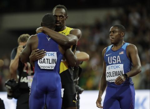 Jamaica's Usain Bolt, bronze, embraces gold medal winner United States' Justin Gatlin as United States' Christian Coleman who took the silver looks on at right after the Men's 100m final during the World Athletics Championships in London, Saturday, Aug. 5, 2017. (AP Photo/David J. Phillip)