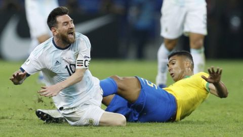 Argentina's Lionel Messi is tackled by Brazil's Casemiro during a Copa America semifinal soccer match at Mineirao stadium in Belo Horizonte, Brazil, Tuesday, July 2, 2019. (AP Photo/Victor R. Caivano)