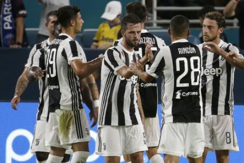Juventus' Claudio Marchisio (8) is congratulated by teammates after scoring apgainst Paris Saint-Germain during the second half of an International Champions Cup soccer match, Wednesday, July 26, 2017, in Miami Gardens, Fla. Juventus won 3-2. (AP Photo/Lynne Sladky)