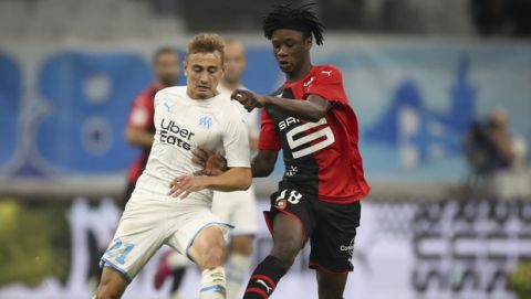Marseille's Valentin Rongier and Rennes' Eduardo Camavinga battle for the ball during the French League One soccer match between Marseille and Rennes at the Velodrome stadium in Marseille, southern France, Sunday, Sept. 29, 2019. (AP Photo/Daniel Cole)