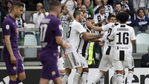 Juventus players celebrate after their teammate Lobo Alex Sandro, fourth from right, scored their side's first goal during a Serie A soccer match between Juventus and AC Fiorentina, at the Allianz stadium in Turin, Italy, Saturday, April 20, 2019. Juventus needs a draw against visiting Fiorentina to clinch a record-extending eighth straight Serie A title. (AP Photo/Luca Bruno)