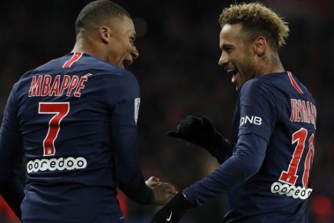 PSG's Kylian Mbappe, left, reacts with PSG's Neymar, celebrating after he scored his side's second goal during the League One soccer match between Paris Saint-Germain and Lille at the Parc des Princes stadium in Paris, Friday, Nov. 2, 2018. (AP Photo/Thibault Camus)