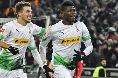 Moenchengladbach's Breel Embolo, right, celebrates his second goal with Patrick Herrmann during the German Bundesliga soccer match between Borussia Moenchengladbach and SC Freiburg in Moenchengladbach, Germany, Sunday, Dec. 1, 2019. (AP Photo/Martin Meissner)