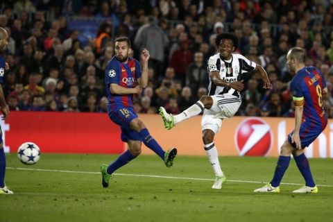 Juventus' Juan Cuadrado, 2nd right, attempts a shot at goal during the Champions League quarterfinal second leg soccer match between Barcelona and Juventus at Camp Nou stadium in Barcelona, Spain, Wednesday, April 19, 2017. (AP Photo/Emilio Morenatti)