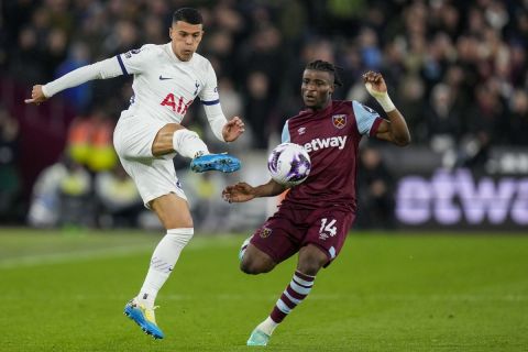 Tottenham's Pedro Porro, left, duels for the ball with West Ham's Mohammed Kudus during the English Premier League soccer match between West Ham and Tottenham, at the London stadium in London, Tuesday, April 2, 2024. (AP Photo/Kirsty Wigglesworth)