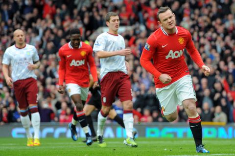 Manchester United's English forward Wayne Rooney (R) celebrates after scoring a penalty during the English Premier League football match between Manchester United and Aston Villa at Old Trafford in Manchester, north-west England, on April 15, 2012. AFP PHOTO/ANDREW YATES
 RESTRICTED TO EDITORIAL USE. No use with unauthorized audio, video, data, fixture lists, club/league logos or live services. Online in-match use limited to 45 images, no video emulation. No use in betting, games or single club/league/player publications (Photo credit should read ANDREW YATES/AFP/Getty Images)