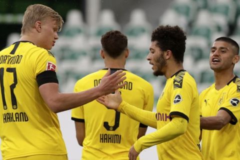 Dortmund's Jadon Sancho celebrate with Erling Haaland, left, after Achraf Hakimi, 2nd left, scored their side's second goal during the German Bundesliga soccer match between VfL Wolfsburg and Borussia Dortmund in Wolfsburg, Germany, Saturday, May 23, 2020. The German Bundesliga is the world's first major soccer league to resume after a two-month suspension because of the coronavirus pandemic. (AP Photo/Michael Sohn, Pool)