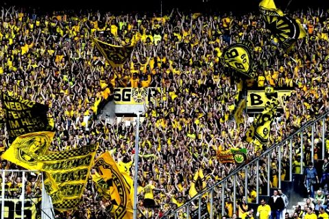 Dortmund's fans celebrate on the guest's tribune prior the German Bundesliga soccer match between Borussia Moenchengladbach and Borussia Dortmund in Moenchengladbach, Germany, Saturday, May 18, 2019. (AP Photo/Martin Meissner)