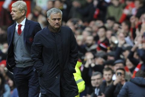 Manchester United manager Jose Mourinho, right, and Arsenal manager Arsene Wenger walk on the pitch at the end of the English Premier League soccer match between Manchester United and Arsenal at the Old Trafford stadium in Manchester, England, Sunday, April 29, 2018. (AP Photo/Rui Vieira)