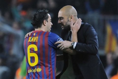 FC Barcelona's coach Pep Guardiola, right, gives instructions to his fellow teammate Xavi Hernandez, during their Champions League second leg, quarterfinal soccer match, against AC Milan, at Camp Nou stadium in Barcelona, Spain Tuesday April 3, 2012. (AP Photo/Alvaro Barrientos)