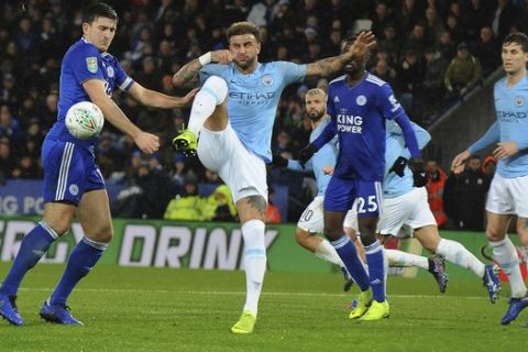 Manchester City's Kyle Walker, centre attempts to clear the ball under pressure from Leicester City's Harry Maguire, left, during the English League Cup quarterfinal soccer match at the King Power stadium in Leicester, England, Tuesday, Dec.18, 2018. (AP Photo/Rui Vieira)