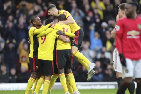 Watford's Ismaila Sarr, unseen in the picture, celebrates with his teammates after scoring his side's opening goal, during the English Premier League soccer match between Watford and Manchester United, at Vicarage Road Stadium, Watford, England, Sunday, Dec. 22, 2019. (AP Photo/Petros Karadjias)