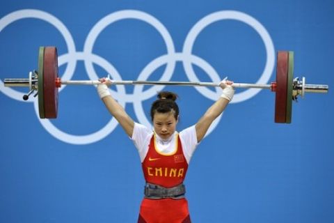 China's Wang Mingjuan lifts during the women's 48kg group A weightlifting competition at The Excel Centre in London on July 28, 2012, during the 2012 Olympic Games. AFP PHOTO / YURI CORTEZ        (Photo credit should read YURI CORTEZ/AFP/GettyImages)