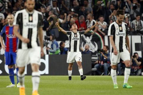 Juventus's Paulo Dybala, center, celebrates after scoring his side's first goal during a Champions League, quarterfinal, first-leg soccer match between Juventus and Barcelona, at the Juventus Stadium in Turin, Italy, Tuesday, April 11, 2017. (AP Photo/Antonio Calanni)