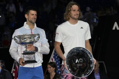 Novak Djokovic, left, of Serbia holds the Norman Brookes Challenge Cup, after defeating Stefanos Tsitsipas, right, of Greece in the men's singles final at the Australian Open tennis championship in Melbourne, Australia, Sunday, Jan. 29, 2023.(AP Photo/Dita Alangkara)
