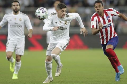 Real Madrid's Federico Valverde vies for the ball with Atletico Madrid's Renan Lodi during the Spanish Super Cup Final soccer match between Real Madrid and Atletico Madrid at King Abdullah stadium in Jiddah, Saudi Arabia, Sunday, Jan. 12, 2020. (AP Photo/Hassan Ammar)