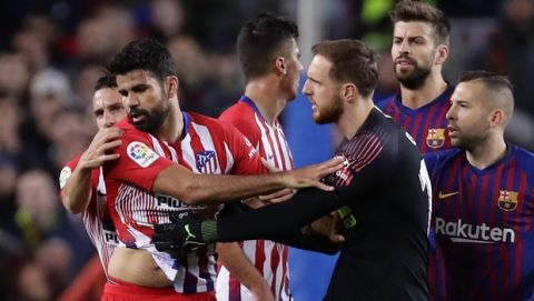 Atletico goalkeeper Jan Oblak, center right, tries to calm down teammate Diego Costa, left, after he was sent off with a red card for insulting referee Jesus Gil Manzano during a Spanish La Liga soccer match between FC Barcelona and Atletico Madrid at the Camp Nou stadium in Barcelona, Spain, Saturday April 6, 2019. (AP Photo/Manu Fernandez)
