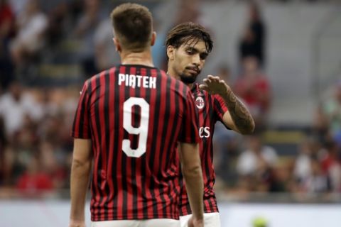 AC Milan's Lucas Paqueta and Krzysztof Piatek, left, walk on the pitch during the Serie A soccer match between AC Milan and Brescia, at the San Siro stadium in Milan, Italy, Saturday, Aug. 31, 2019. (AP Photo/Luca Bruno)