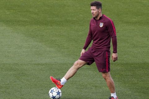 Atletico de Madrid head coach Diego Pablo Simeone plays with a ball during a training session ahead of Wednesday's Champions League semifinal, 2nd leg soccer match between Atletico de Madrid and Real Madrid, in Madrid, Spain, Tuesday, May 9, 2017 . (AP Photo/Daniel Ochoa de Olza)