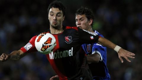 Chile's Universidad de Chile's Igor Lichnovsky, back, fights for a ball with Argentina's Newells' Old Boys's Ignacio Scocco during a Copa Libertadores soccer match in Santiago, Chile, Tuesday, March 12, 2013. (AP Photo/Luis Hidalgo)