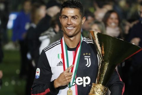 Juventus' Cristiano Ronaldo holds up the Serie A soccer title trophy, at the Allianz Stadium, in Turin, Italy, Wednesday, April 3, 2019. (AP Photo/Antonio Calanni)