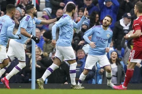 Manchester City's Ilkay Gundogan, center, celebrates after scoring the opening goal during an English FA Cup fourth round soccer match between Manchester City and Fulham at the Etihad Stadium in Manchester, England, Sunday, Jan. 26, 2020. (AP Photo/Jon Super)