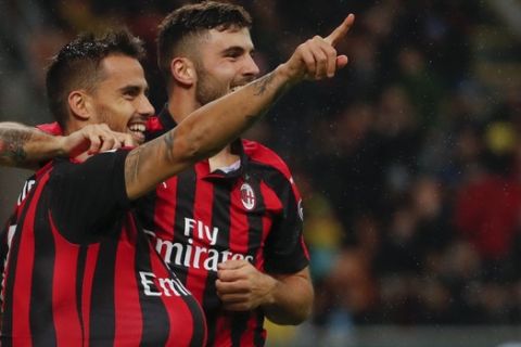 AC Milan's Suso, left, celebrates with his teammate Patrick Cutrone after scoring his side's opening goal during the Serie A soccer match between AC Milan and Genoa at the San Siro Stadium in Milan, Italy, Wednesday, Oct. 31, 2018. (AP Photo/Antonio Calanni)