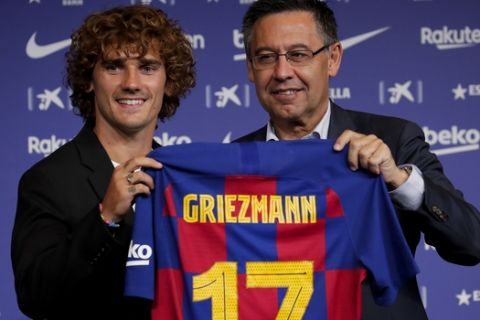 French forward Antoine Griezmann, left, holds up his new team shirt with FC Barcelona's President Josep Maria Bartomeu during his official presentation after signing for FC Barcelona in Barcelona, Spain, Sunday, July 14, 2019. (AP Photo/Emilio Morenatti)