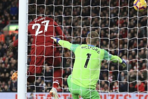Liverpool forward Divock Origi, center, scores his side's first goal during the English Premier League soccer match between Liverpool and Everton at Anfield Stadium in Liverpool, England, Sunday, Dec. 2, 2018. (AP Photo/Jon Super)