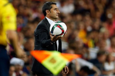 Athletic Bilbao's head coach Ernesto Valverde holds the ball during a second leg Spanish Super Cup soccer match between FC Barcelona and Athletic Bilbao at the Camp Nou stadium in Barcelona, Spain, Monday, Aug.17, 2015. (AP Photo/Manu Fernandez)