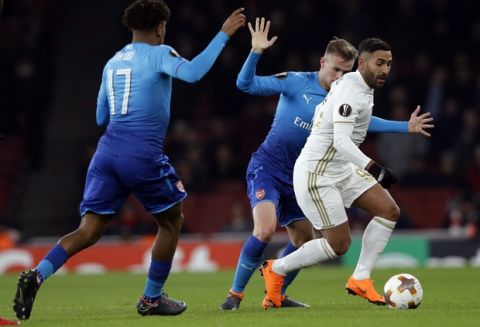 Ostersunds' Saman Ghoddos, right, battles for the ball with Arsenal's Rob Holding, center and Arsenal's Alex Iwobi during the Europa League Round of 32, second leg soccer match between Arsenal and Ostersunds FK at the Emirates Stadium in London, Thursday, Feb. 22, 2018. (AP Photo/Alastair Grant)