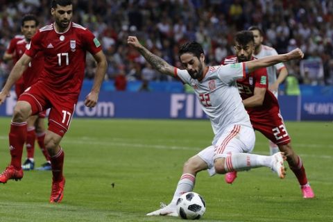Spain's Isco, front, is challenged by Iran's Mehdi Taremi, left, during the group B match between Iran and Spain at the 2018 soccer World Cup in the Kazan Arena in Kazan, Russia, Wednesday, June 20, 2018. (AP Photo/Manu Fernandez)