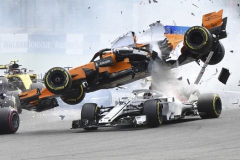 The car of Mclaren driver Fernando Alonso of Spain, center top, is involved in a crash along with Sauber driver Charles Leclerc of Monaco. center bottom, during the Belgian Formula One Grand Prix in Spa-Francorchamps, Belgium, Sunday, Aug. 26, 2018. (AP Photo/Geert Vanden Wijngaert)
