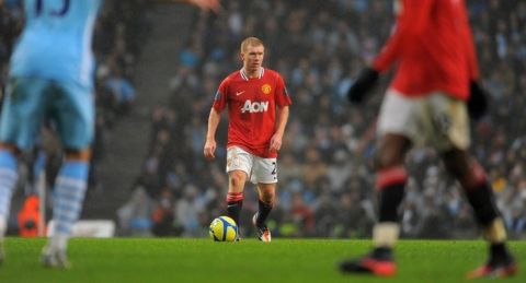 Manchester United's English midfielder Paul Scholes (C) controls the ball during the FA Cup third round football match between Manchester City and Manchester United at The Etihad stadium in Manchester, north-west England on January 8 2012. AFP PHOTO/ANDREW YATES. RESTRICTED TO EDITORIAL USE. No use with unauthorized audio, video, data, fixture lists, club/league logos or live services. Online in-match use limited to 45 images, no video emulation. No use in betting, games or single club/league/player publications. (Photo credit should read ANDREW YATES/AFP/Getty Images)