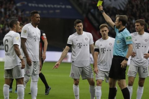 Bayern's Jerome Boateng, is shown a yellow card for the tackleon Frankfurt's Goncalo Paciencia and a penalty was given during a German Bundesliga soccer match between Eintracht Frankfurt and Bayern Munich in the Commerzbank Arena in Frankfurt, Germany, Saturday, Nov. 2, 2019. (AP Photo/Michael Probst)