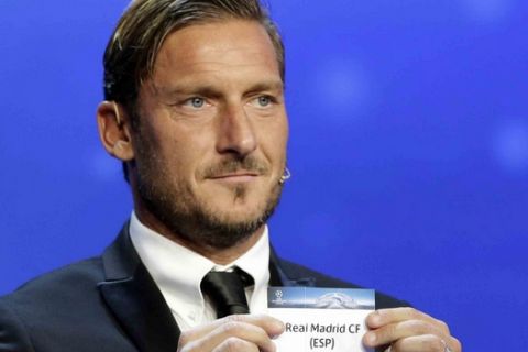 Former Italian player Francesco Totti shows the name of Real Madrid, who will play in Group H during the UEFA Champions League draw at the Grimaldi Forum, in Monaco, Thursday, Aug. 24, 2017. (AP Photo/Claude Paris)