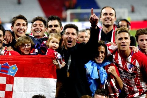 Atletico's head coach Diego Simeone, in black suit, celebrates with his players after winning the Europa League Final soccer match between Marseille and Atletico Madrid at the Stade de Lyon in Decines, outside Lyon, France, Wednesday, May 16, 2018. (AP Photo/Thibault Camus)