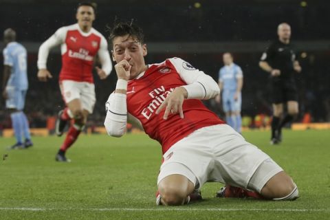 Arsenal's Mesut Ozil celebrates after scoring a goal during the English Premier League soccer match between Arsenal and Stoke City at the Emirates stadium in London, Saturday Dec. 10, 2016. (AP Photo/Tim Ireland)