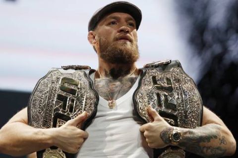 Conor McGregor holds up belts during a news conference for the UFC 229 mixed martial arts bouts Thursday, Oct. 4, 2018, in Las Vegas. McGregor is scheduled to fight Khabib Nurmagomedov Saturday in Las Vegas. (AP Photo/John Locher)