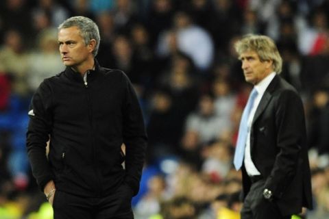 Real Madrid's Portuguese coach Jose Mourinho (L) looks on in front of Malaga's Chilean coach Manuel Pellegrini (R) during the Spanish league football match Real Madrid vs Malaga at the Santiago Barnabeu stadium in Madrid on March 18, 2012. The match ended 0-0 draw.   AFP PHOTO/JAVIER SORIANO (Photo credit should read JAVIER SORIANO/AFP/Getty Images)