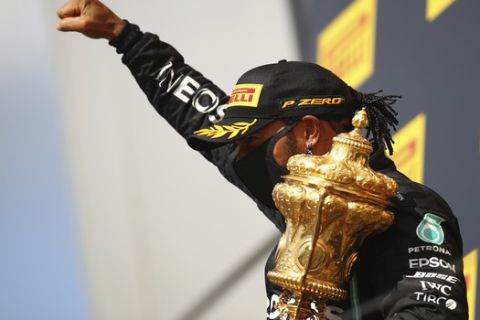 Mercedes driver Lewis Hamilton of Britain celebrates on the podium after winning the British Formula One Grand Prix at the Silverstone racetrack, Silverstone, England, Sunday, Aug. 2, 2020. (Bryn Lennon/Pool via AP)